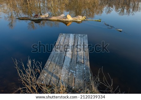 Old wooden jetty above the water in the river. Natural background.