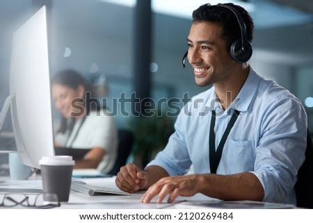 Where would we be without loyal customers like you. Shot of a young man using a headset and computer in a modern office. Royalty-Free Stock Photo #2120269484