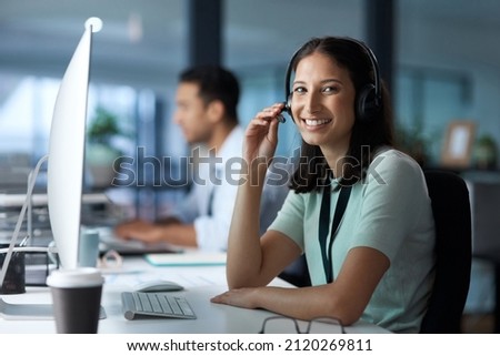 I hear you. Portrait of a young woman using a headset and computer in a modern office. Royalty-Free Stock Photo #2120269811