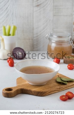 A plate with healthy homemade bone broth on a wooden board. The concept of healthy food.