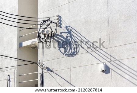 Wire and shadows on a concrete building wall