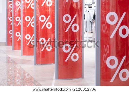 Shopping center. Red bright sale word banner on anti-thieft gate sensor at retail shopping mall entrance. Seasonal discount offer in store