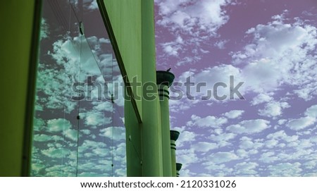 Cloudy summer sky, sun shines. Africa exotic landscape. White clouds, purple sky, green walls, mirror reflection. 