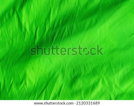 Vast view of Green screen background. Used as negative space, backdrop, chroma key wallpaper, studio photo photography. Wrinkled textiles cloth material. Chroma key objects
