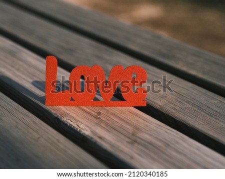 red decorative love lettering on wooden board