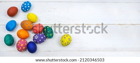 Easter background. Multicolored Easter eggs on a white wooden background. Banner. copy space