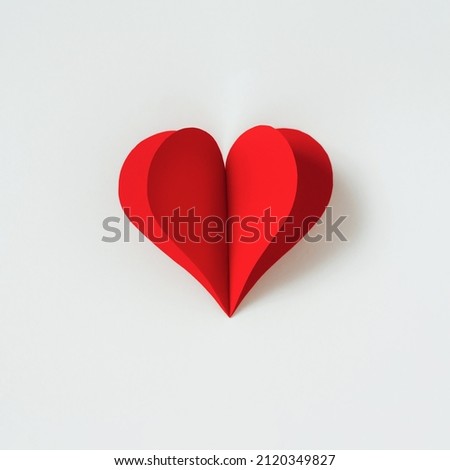 Paper red heart shape decoration on white background. Valentines day greeting card. Minimal concept of Cute love, romantic, wedding or mothers day. Flat lay, top view, copy space.