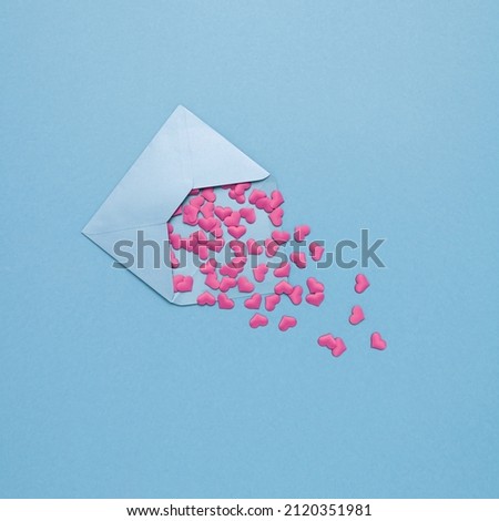 Love letter with pink  hearts against blue vibrant background. Minimal Valentines Day, wedding or Mother's day concept. Creative love romantic emotion composition. Holiday invitation card.