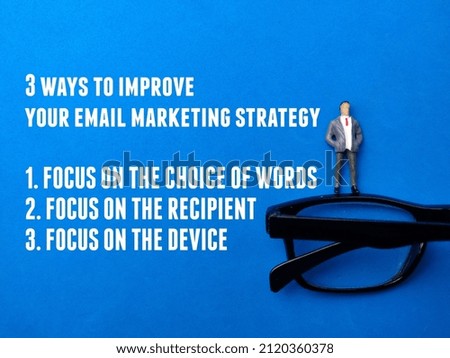 Top view miniature people and glasses with tips for email marketing strategy on a blue background. Business concept.