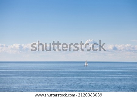 Panorama of the adriatic sea, a blue sea with a sunny blue sky, with a sailboat, a sailing ship passing by over the horizon, during holidays and vacation in summer. 

 Royalty-Free Stock Photo #2120363039