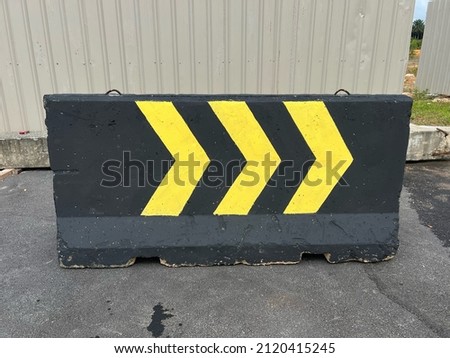 Concrete barrier in road construction painted with black and yellow colour.