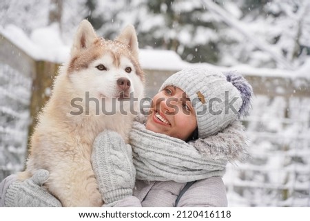 Image of young girl with her dog, alaskan malamute, outdoor at autumn or winter. domestic pet. Husky.