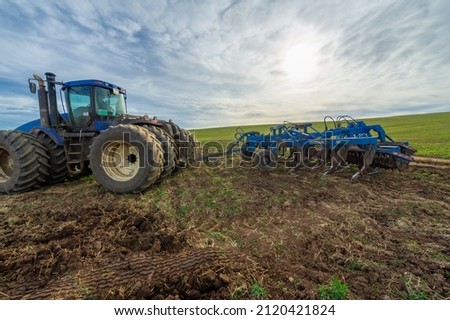 The tractor plows the land. Fertile black earth field. Autumn landscape photography, European part of the Earth.