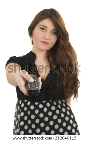 Young pretty girl holding remote control pointing to the camera isolated on white