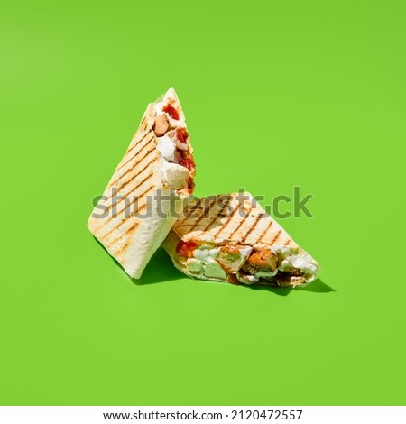 Shawarma with vegetables and meat on green background. Contemporary poster with shawarma. Doner kebab in minimal style. Street food concept. Junk food design. Minimalistic fast food menu