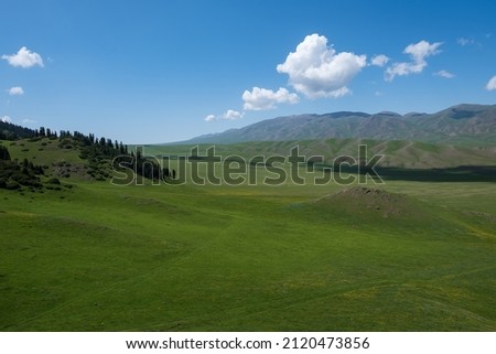 Beautiful green mountains with cloudy sky on background in spring season. Mountain valley landscape. Colorful scenery. Beautiful summer landscape. Tourism, travel in Kazakhstan concept. Assy plateau.