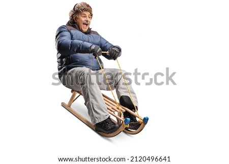 Excited mature man riding on a wooden sleigh isolated on white background
