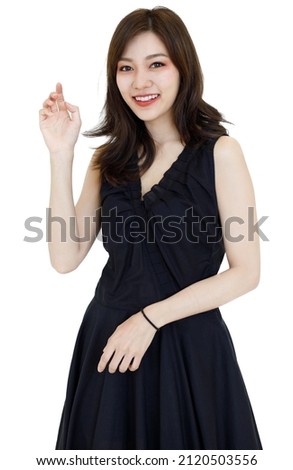 Portrait isolated cutout studio shot Asian pretty friendly young long hair female model wears makeup in casual black dress standing posing smiling look at camera with copy space on white background.