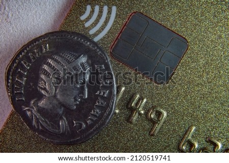 Old coin near NFC chip close up