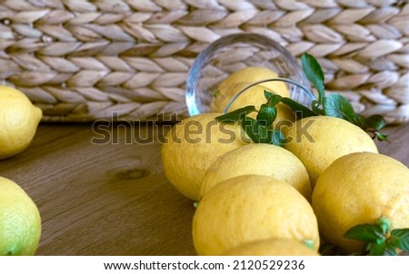 Home made lemonade ingredients, fresh lemons in a baske peppermint on rustic brown wooden background