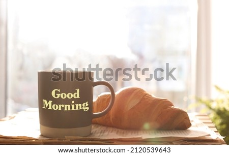 Good Morning. Delicious coffee, newspaper and croissant near window indoors
