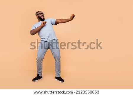Full length body size view of attractive cheerful cool guy moving clubbing having fun isolated over beige pastel color background Royalty-Free Stock Photo #2120550053