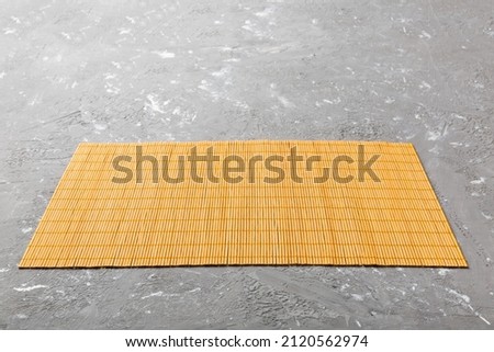Perspective view of yellow tablecloth for food on cement background. Empty space for your design.