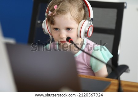 Little cute child watch cartoon on laptop or studying online, kid wear headset with microphone
