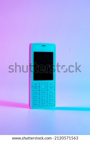 Retro wave vintage concept. White old mobile telephone in neon pink blue light. Retro wave. Pop art. minimal idea concept