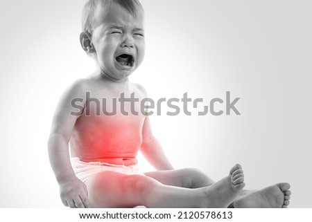 Crying little baby boy suffering from stomachache Royalty-Free Stock Photo #2120578613
