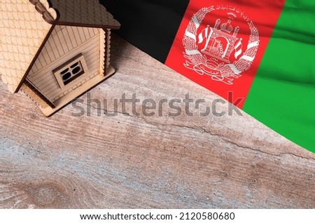 House model near Afghanistan flag. Real estate sale and purchase concept. Space for text.
