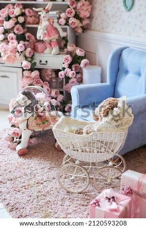 The interior of the children's room in vintage style in blue and pink tones. A chair, toys and a stroller.