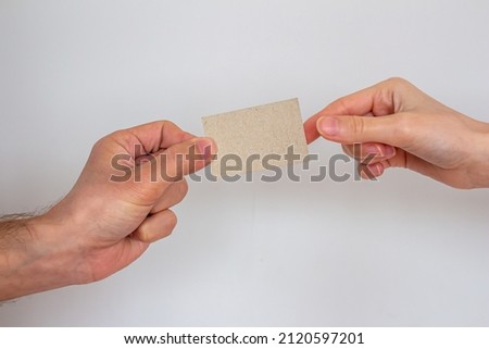Man giving empty business card to woman isolated on gray wall background, mockup business card template. Copy space for text.
