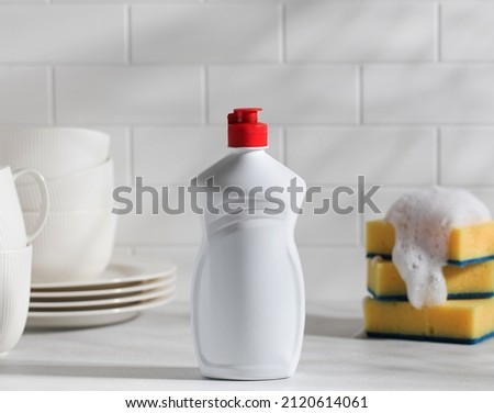 Mockup white plastic with dishwashing gel with shadows and yellow sponges with foam on top  Royalty-Free Stock Photo #2120614061