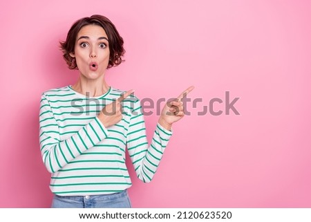 Portrait of attractive amazed girl demonstrating copy blank space advert new info isolated over pink pastel color background