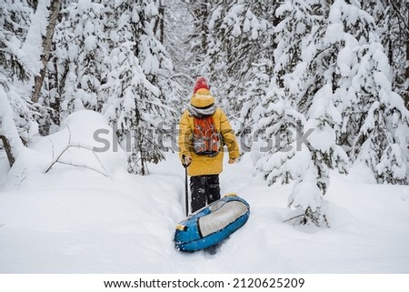 brave traveller. hiking backpack on the back of the traveler. Snowy forest and rocks. Climbing the mountain in winter. Survival in the wild. High quality photo