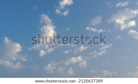 Beautiful small white clouds on blue sky background. Nature photography. Elegant blue sky picture in sunlight. Big or tiny and soft white fluffy clouds in the blue sky. Coudy blue sky background