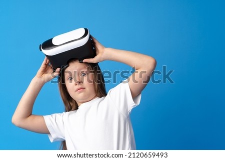 Girl with virtual reality glasses on blue background.