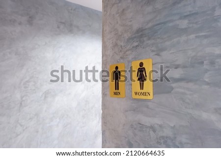 Male and female toilet sign on plaster texture background.