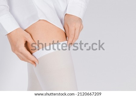 Anti-embolic Compression Hosiery for surgery isolated on white. Medical white stockings, tights for varicose veins and venouse therapy. Thrombo embolic deterrent hose or anti-embolism stockings. Royalty-Free Stock Photo #2120667209