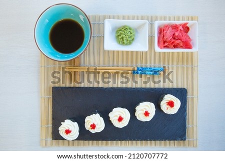 Maki roll with salmon, popular Japanese cuisine. Sushi roll with fish, cream cheese and vegetables. Healthy food.
