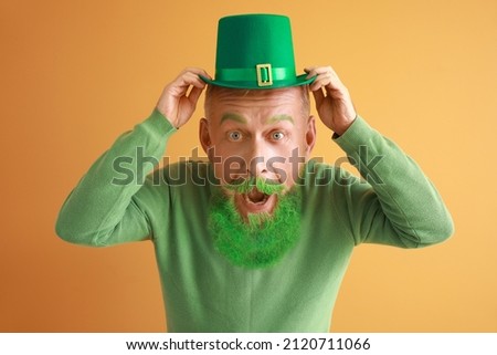 Funny mature man with big head and green hat on color background. St. Patrick's Day celebration