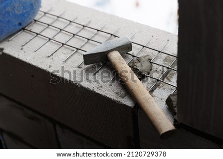 steel hammer lies on the masonry at the construction site. steel mesh for reinforcing the masonry of concrete blocks of gas blocks.