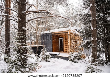 Modular house made of dark metal and light wood in winter forest. a house that takes into account everything you need for a comfortable life outside the city. High quality photo