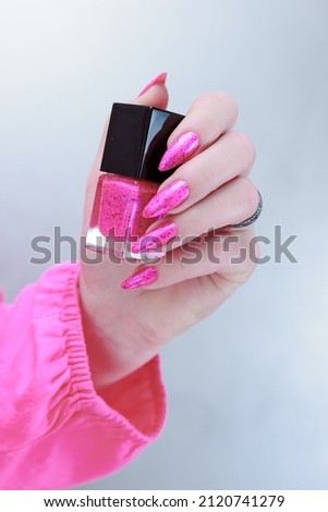 beautiful Female hands with long nails and neon pink nail polish