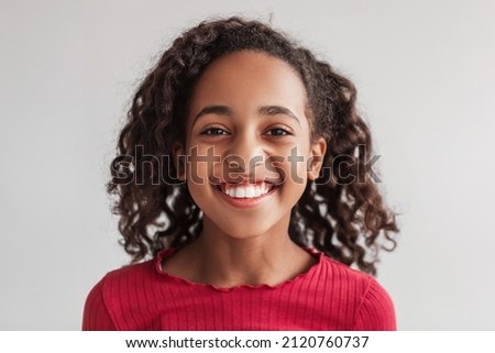 Headshot Of Positive African American Preteen Girl Smiling Posing Looking At Camera On Gray Background In Studio, Wearing Casual Clothes. Child's Portrait. Kids Beauty And Style Concept. Front View Royalty-Free Stock Photo #2120760737