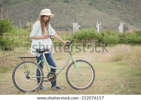 Woman with vintage camera in hand and bicycle