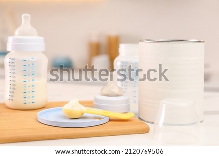 Feeding bottle with infant formula and powder on white table indoors Royalty-Free Stock Photo #2120769506