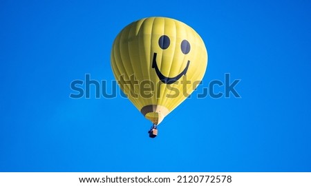 A yellow hot air balloon in the blue sky Royalty-Free Stock Photo #2120772578