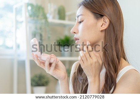 Dermatology, puberty asian young woman, girl looking into mirror, allergy when wear mask and cosmetic, show squeezing pimple spot for removing from face.Beauty care from skin problem by acne treatment Royalty-Free Stock Photo #2120779028